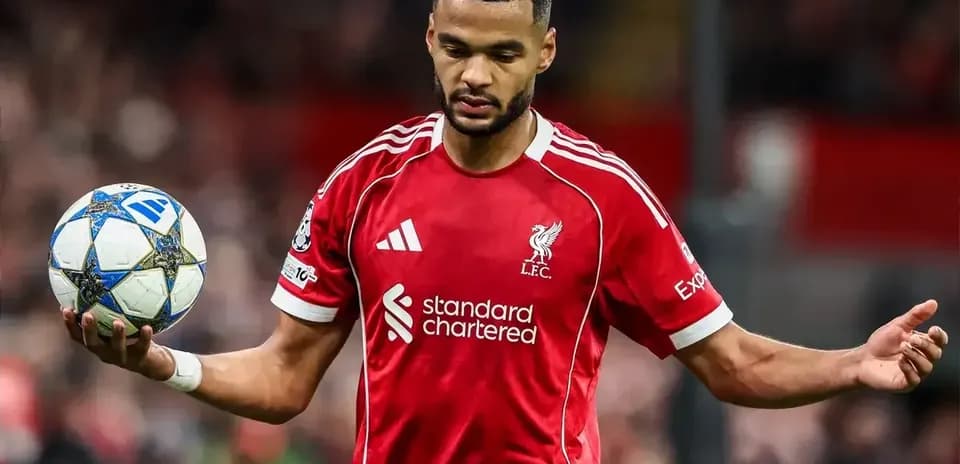 Player in Liverpool kit holding a football