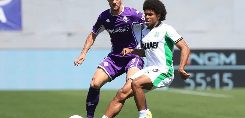 Fiorentina player tackling Sassuolo opponent