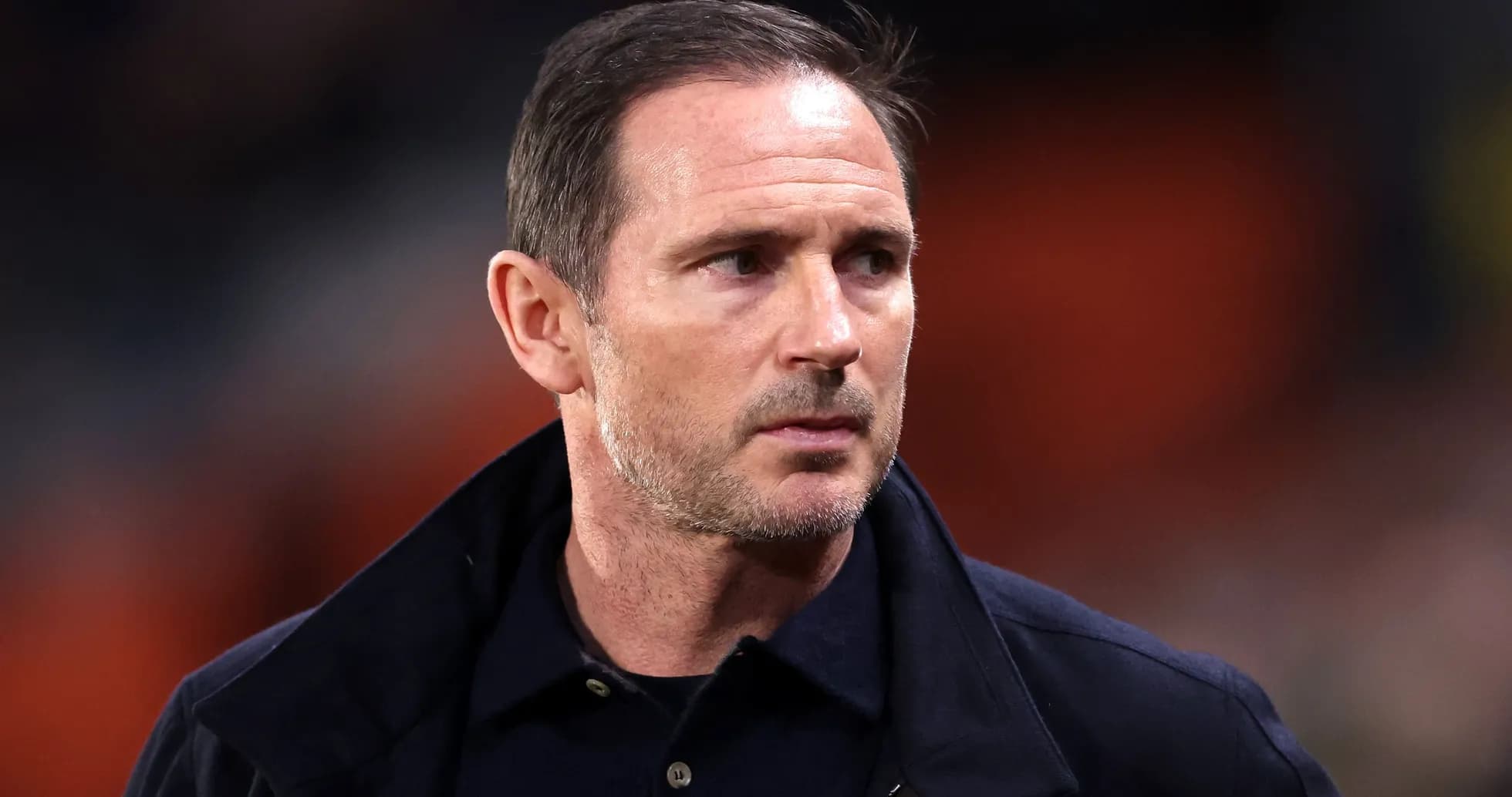Football manager walking on the pitch sidelines