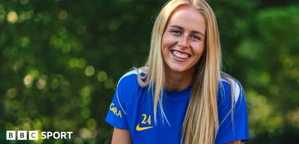 Player smiling in blue jersey outdoors