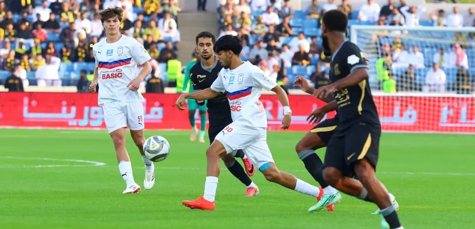 Players competing for the ball during football match