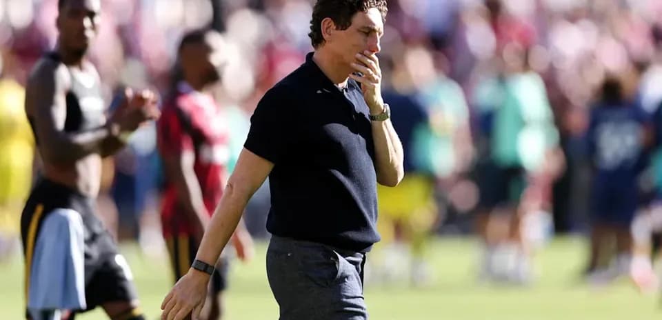 Coach walking past players after match conclusion