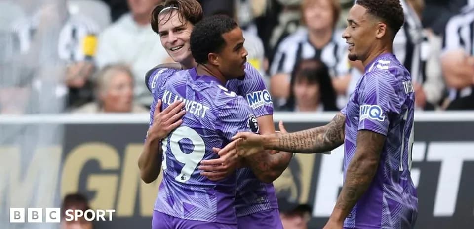 Three players celebrating a goal on the pitch