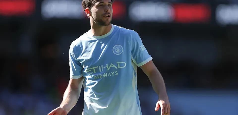 Player in light blue Manchester City kit on field