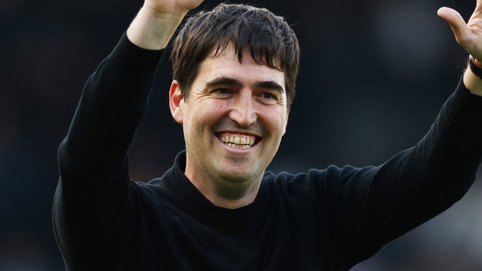 Coach celebrating with a raised hand and smile