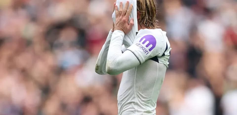 Player pulling shirt over head in frustration during match