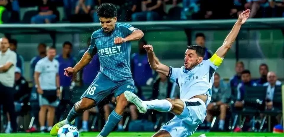 Player tackles opponent during UEFA Champions League match