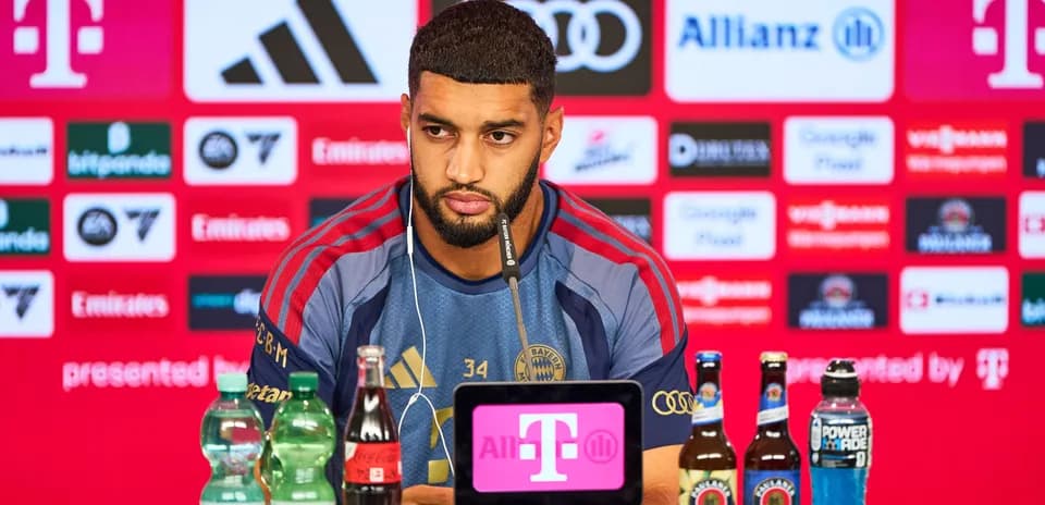Player at press conference with sponsors' logos behind