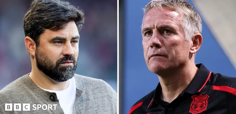 Two football managers on the sidelines during a match