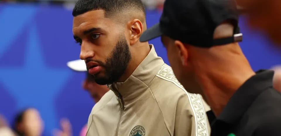 Player in team tracksuit talking with another person