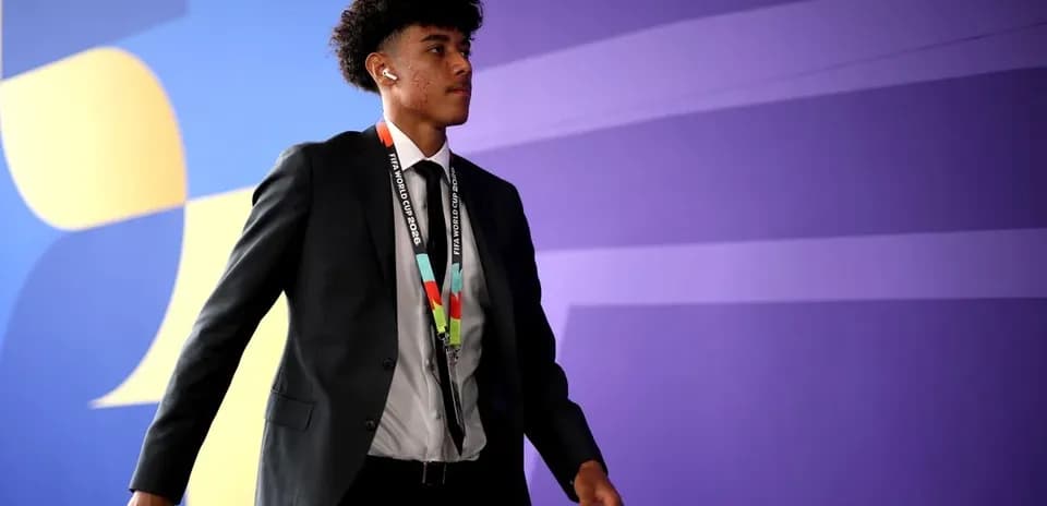 Player walking in suit with FIFA World Cup lanyard