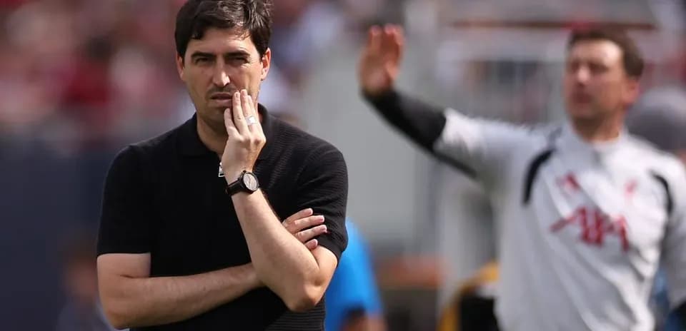 Coach observing the match with hand on chin