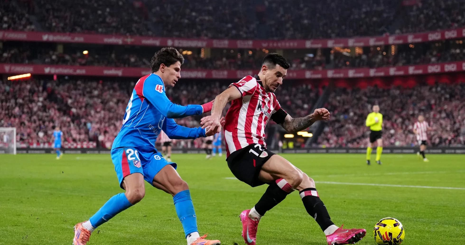 Atletico Madrid player tackling Athletic Club opponent