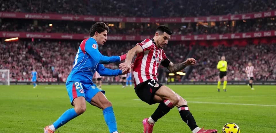 Atletico Madrid player tackling Athletic Club opponent