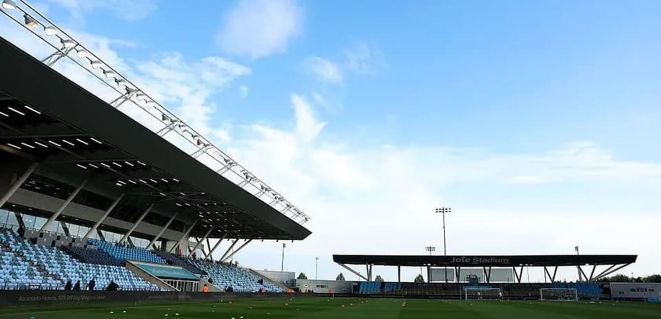 Joie Stadium with empty stands and blue sky