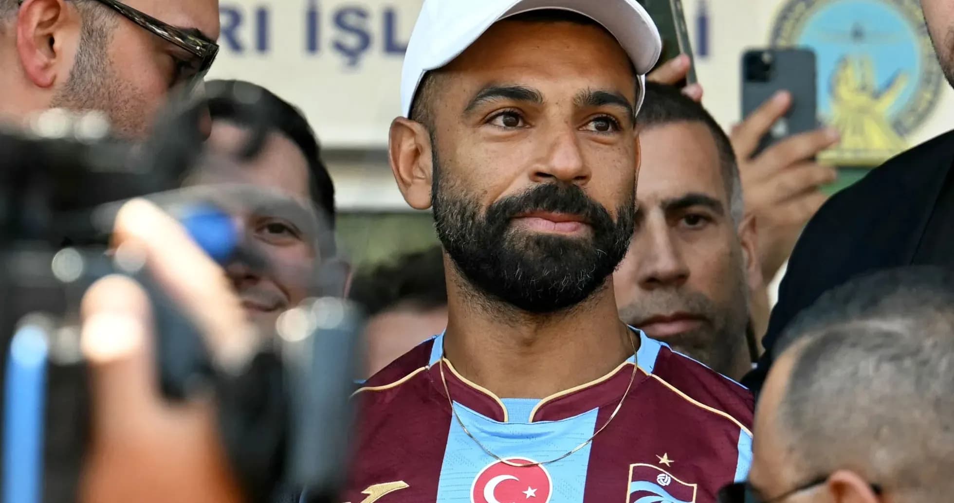 Player in Trabzonspor jersey surrounded by fans