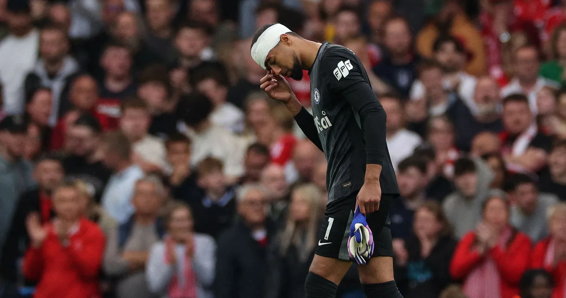 Goalkeeper walking off the pitch with bandaged head