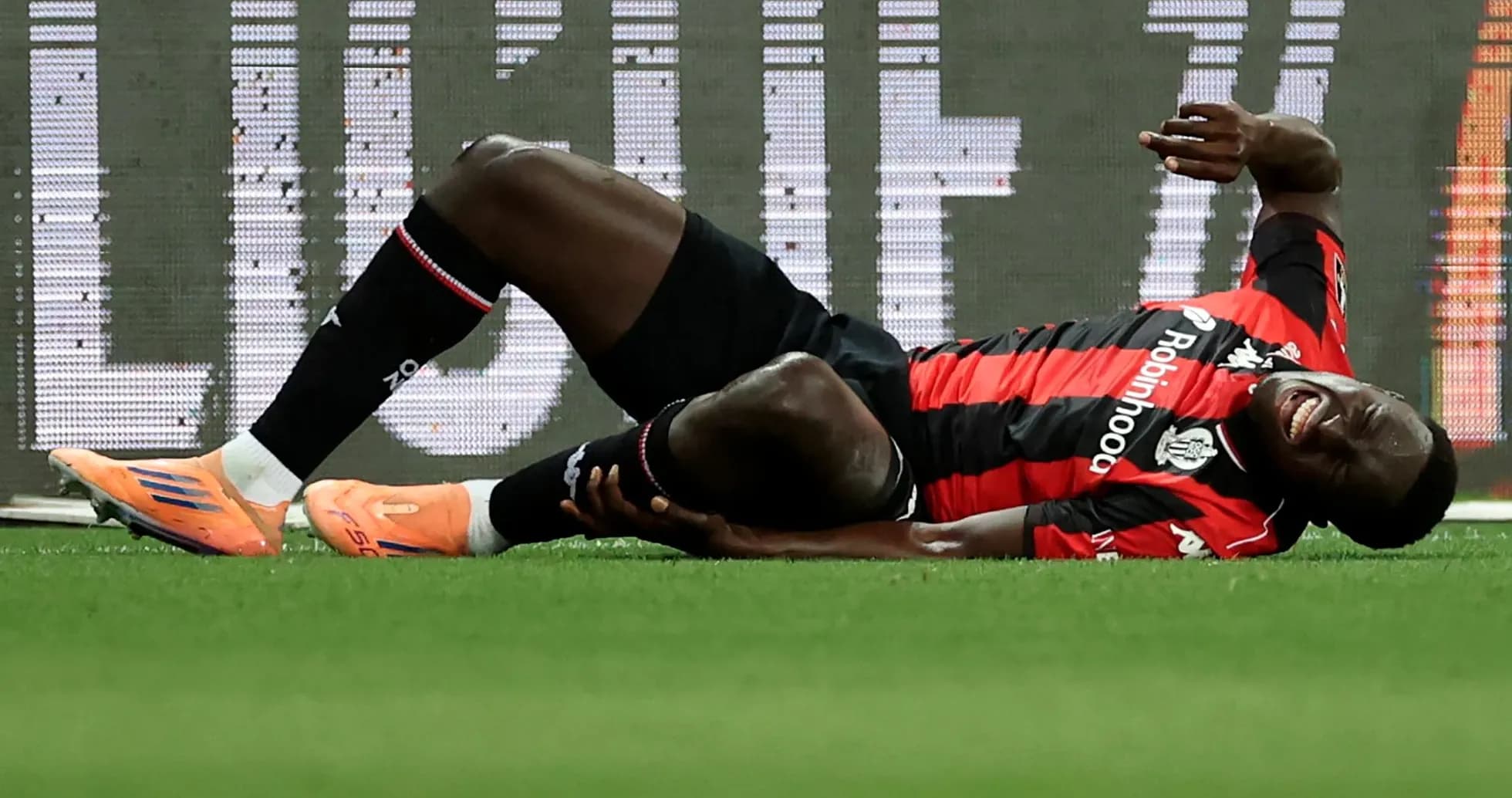 Player on the ground holding injured leg during match
