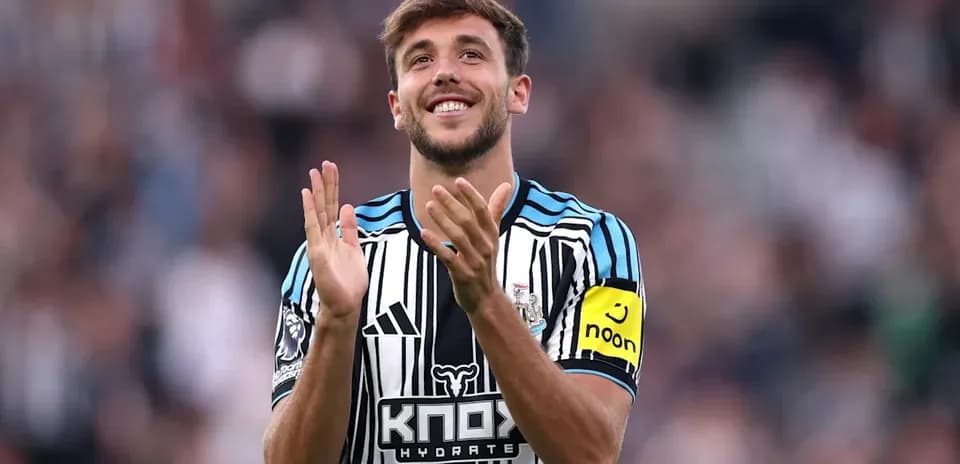 Player clapping and smiling in Newcastle kit