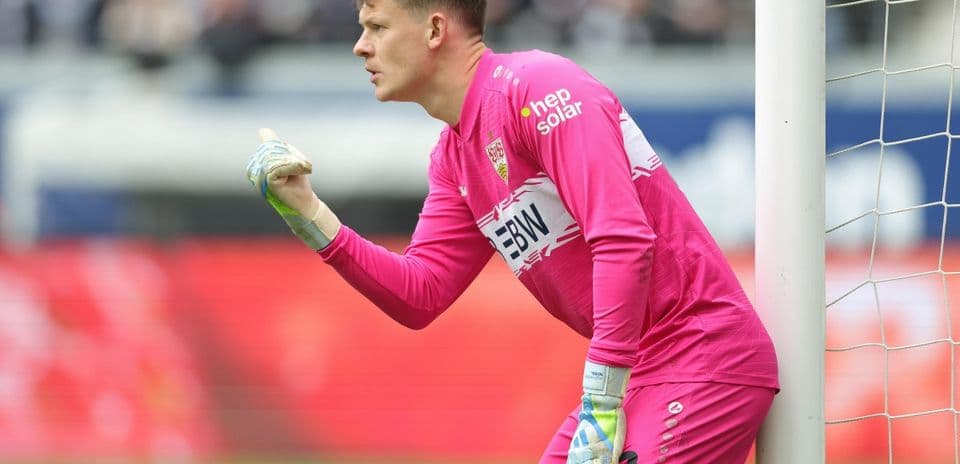 Goalkeeper in pink kit directing play during match