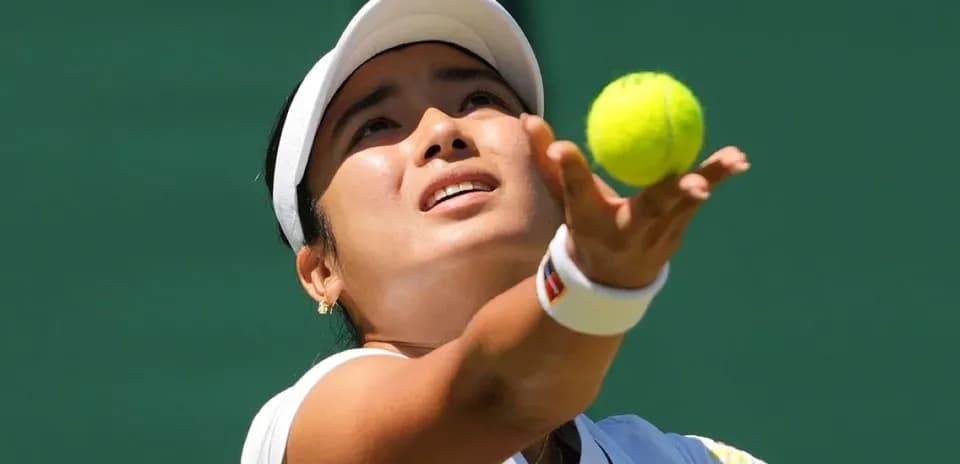 Tennis player serving a ball during match