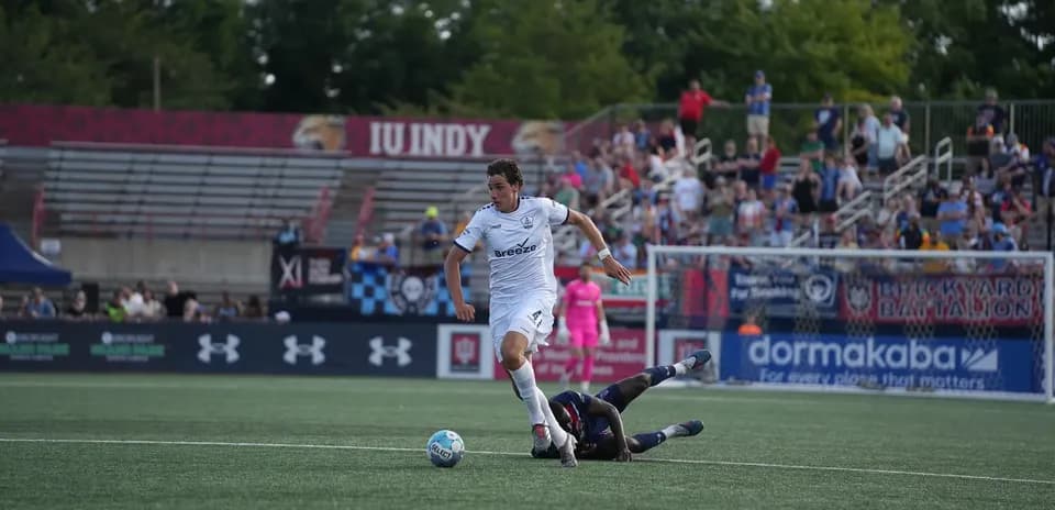 Player dribbling past opponent during USL match
