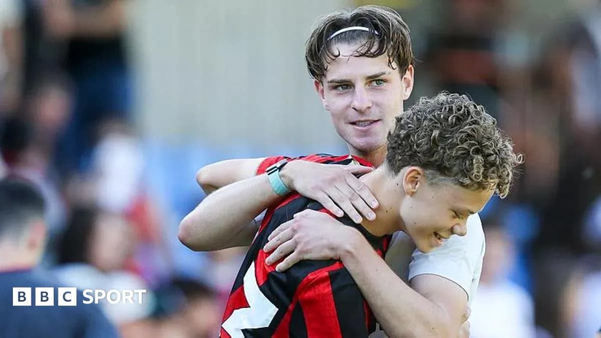 Two players embracing on the football pitch
