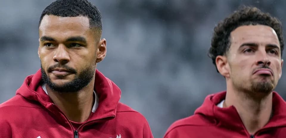 Two Liverpool players in red training jackets
