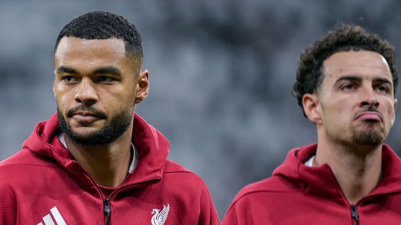 Two Liverpool players in red training jackets