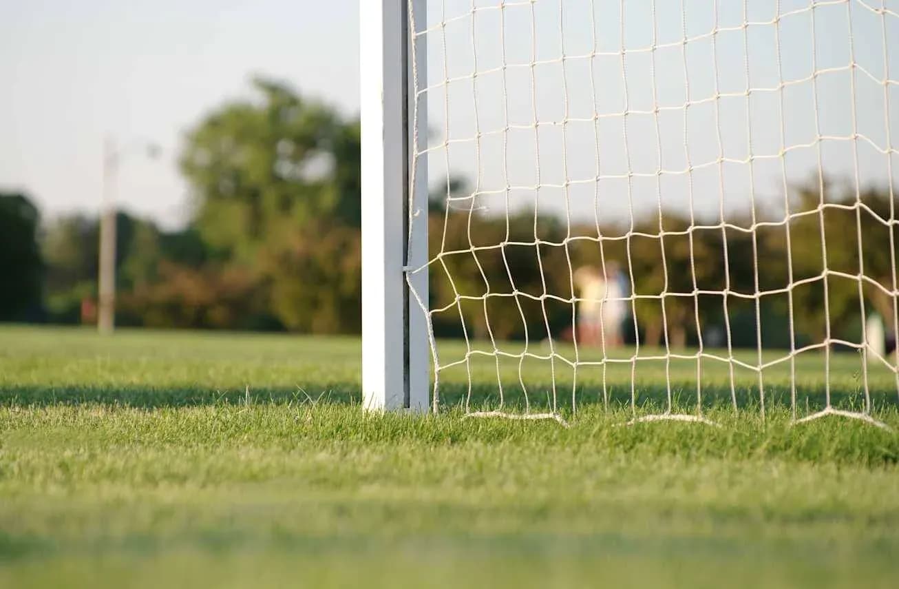 Close-up of soccer goal and net on field