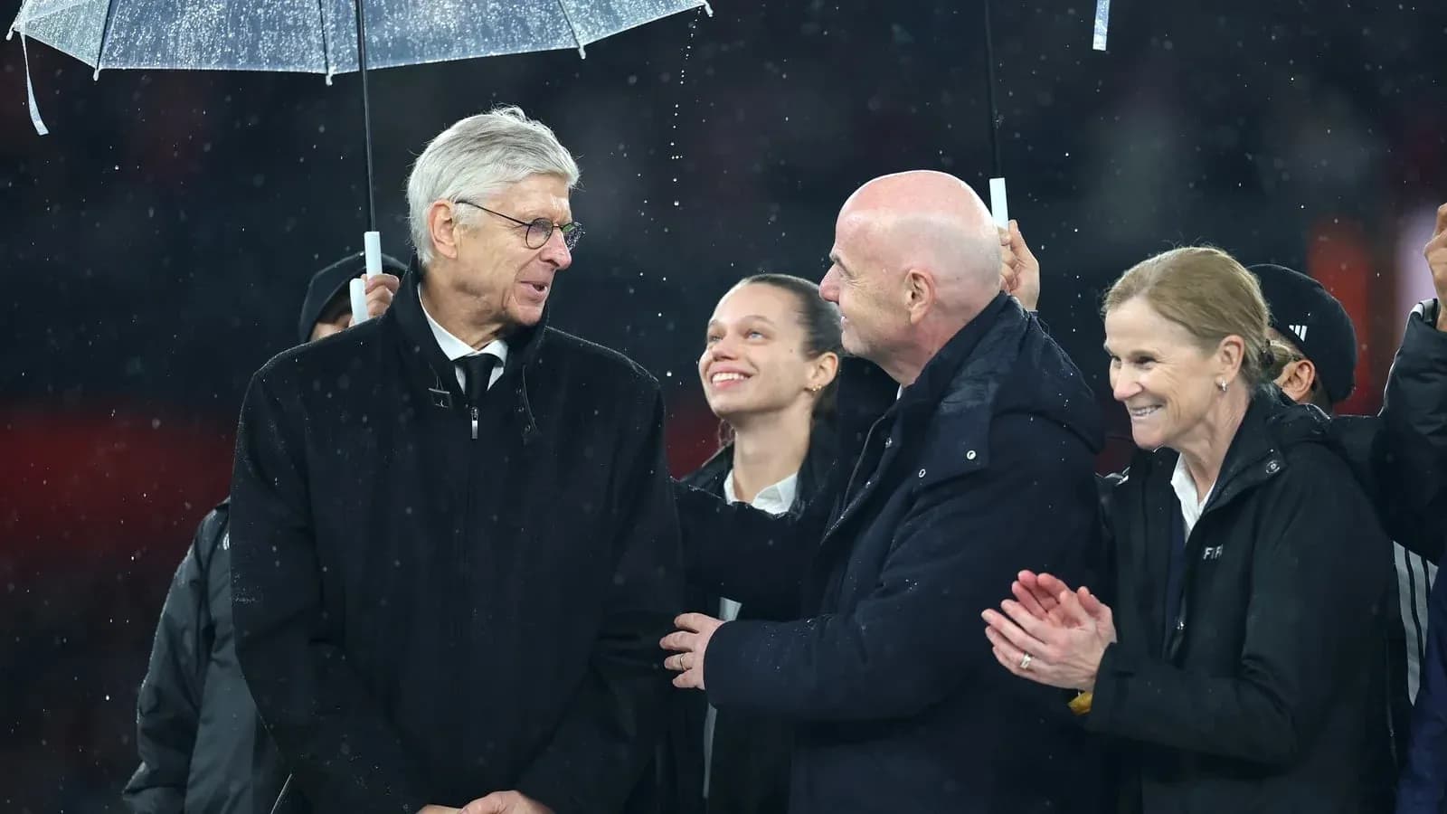 Group of people under an umbrella during rain