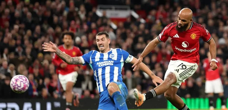 Brighton player tackling Manchester United forward