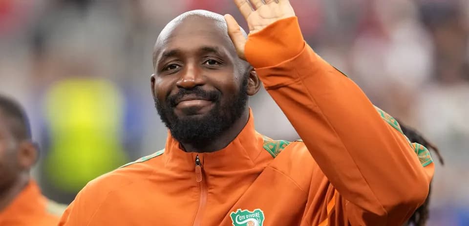 Player waving while wearing Cote d'Ivoire jacket