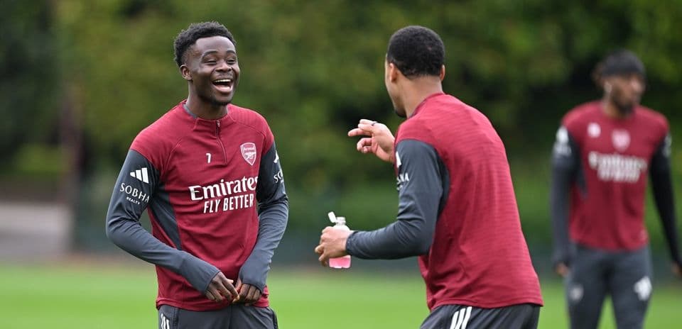 Two Arsenal players laughing during training session