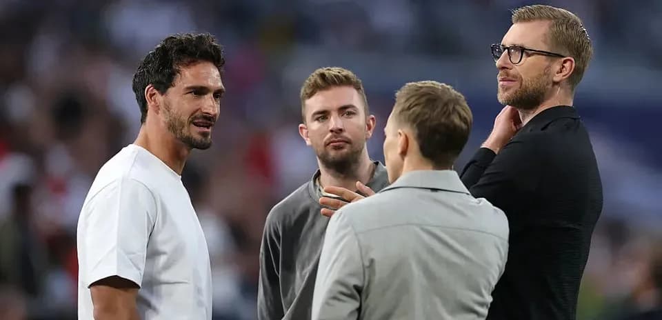 Four men talking on the sidelines of a match