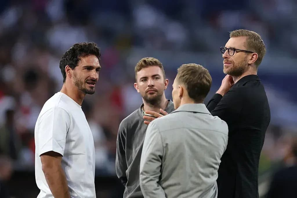 Four men talking on the sidelines of a match