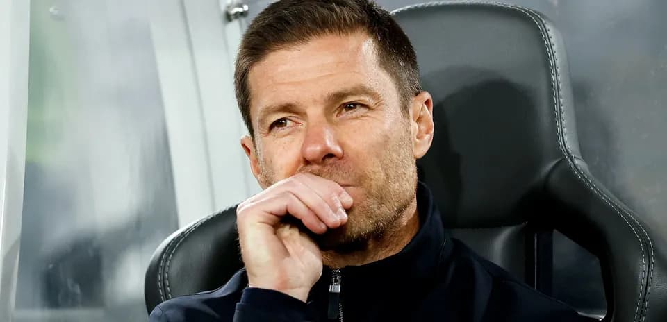 Coach sitting on bench during match contemplation
