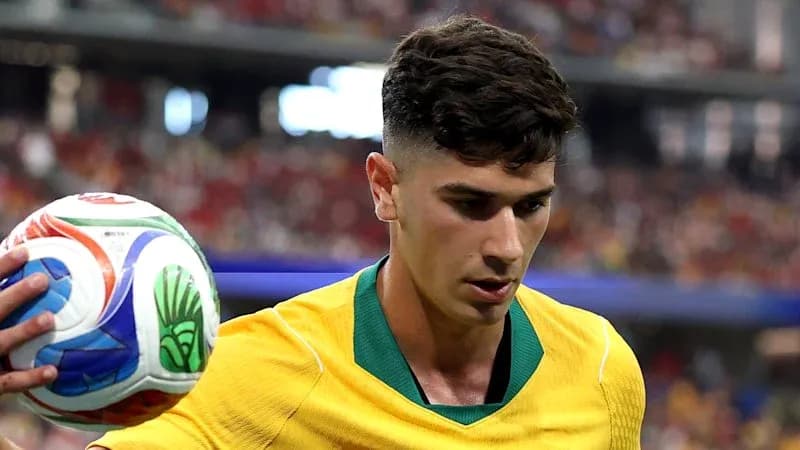 Player in yellow jersey holding soccer ball on field