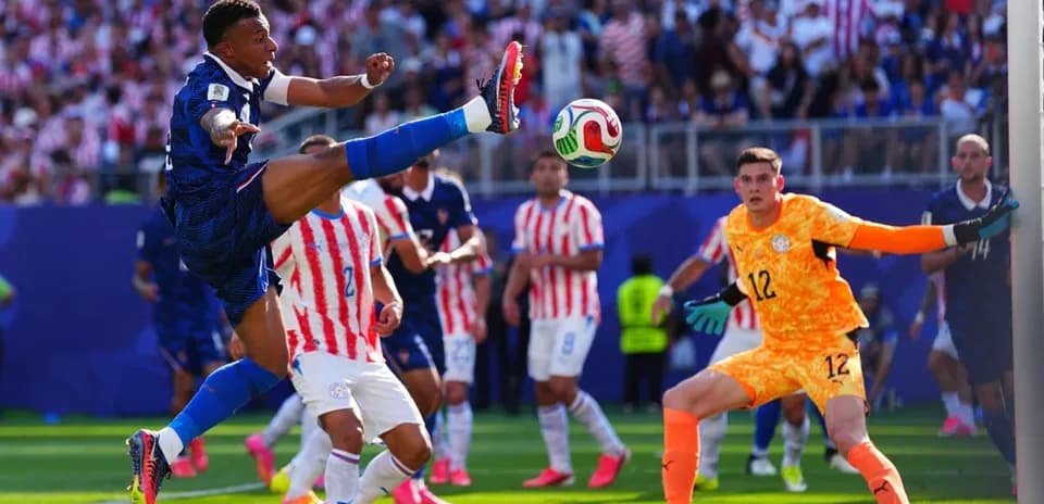 Player kicking ball during match with goalkeeper nearby