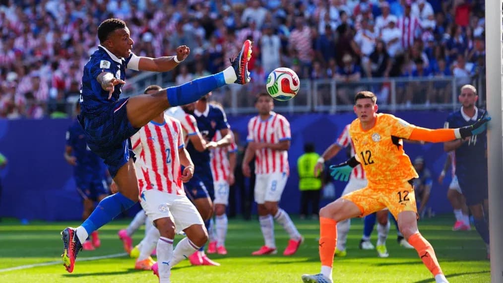 Player kicking ball during match with goalkeeper nearby