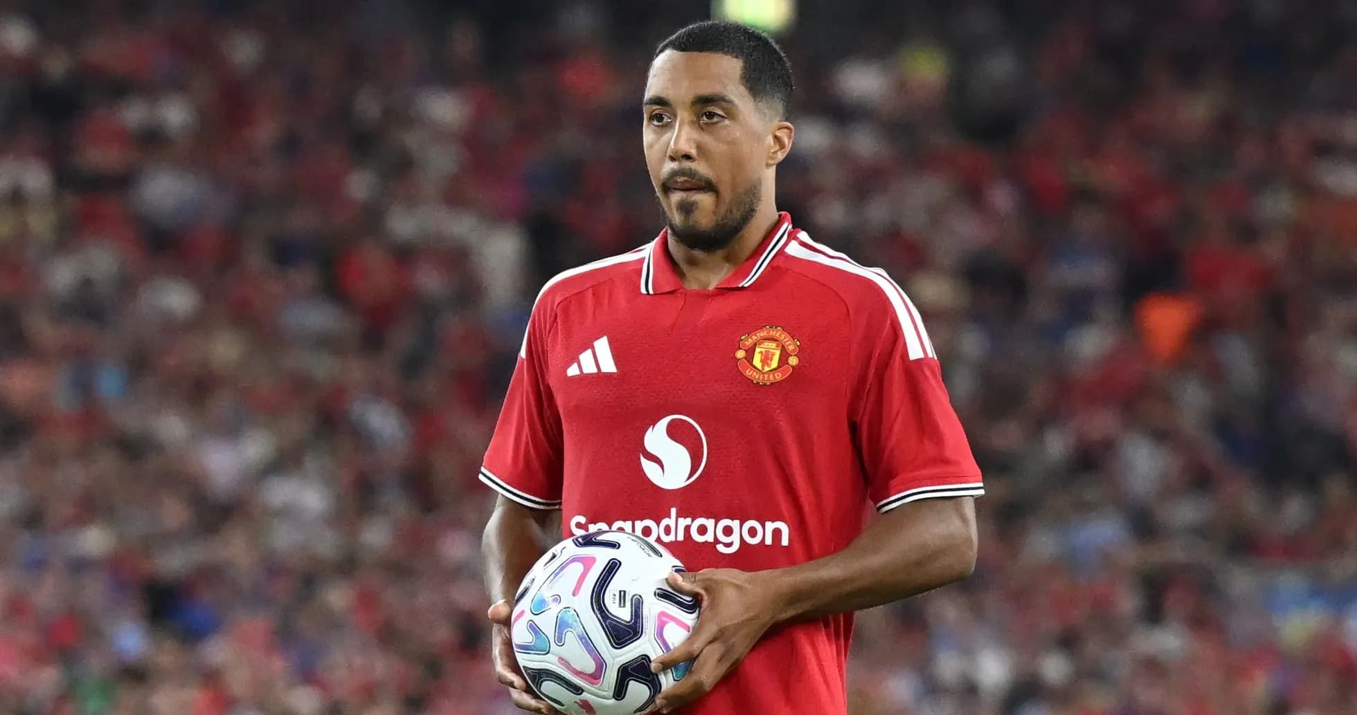Player in red Manchester United jersey holding ball