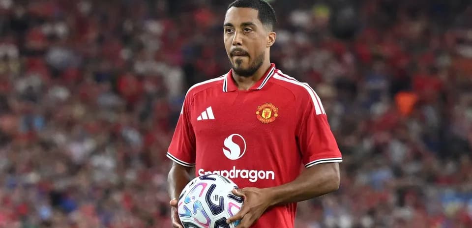 Player in red Manchester United jersey holding ball