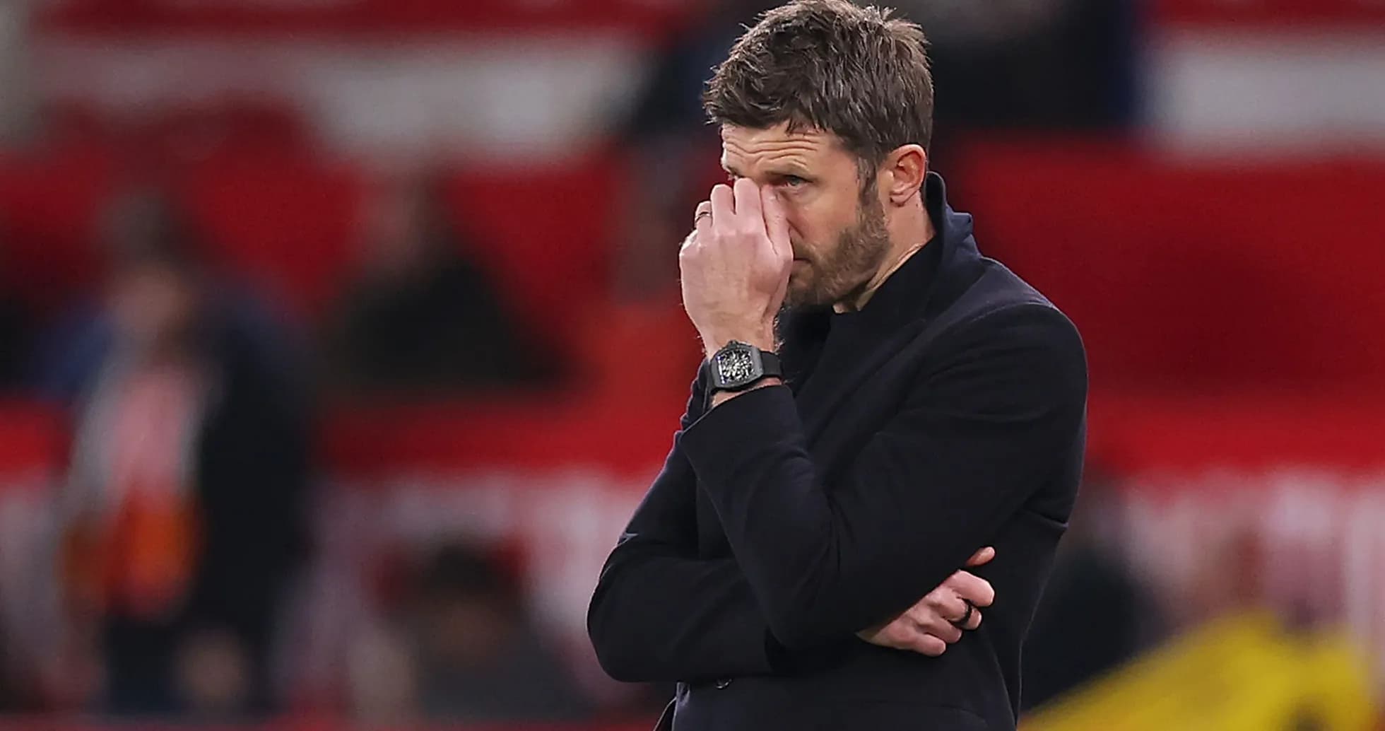 Coach observing match with hand on face