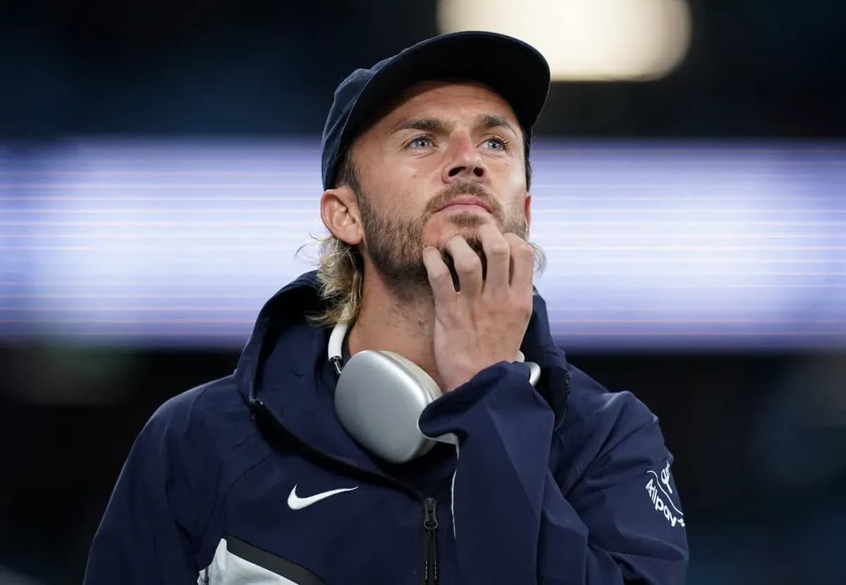 Man in sportswear thinking with headphones around neck