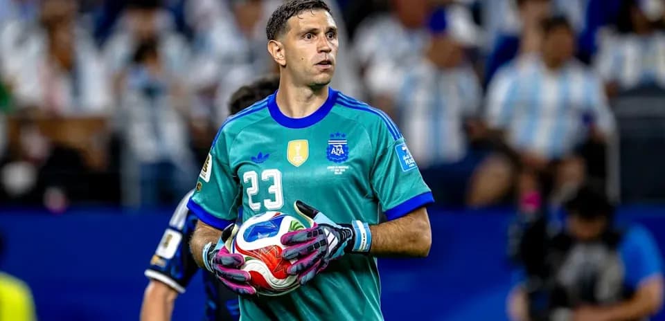 Goalkeeper in teal uniform holding a soccer ball