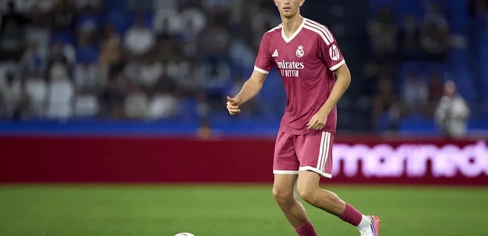 Player in pink kit dribbling the ball on field