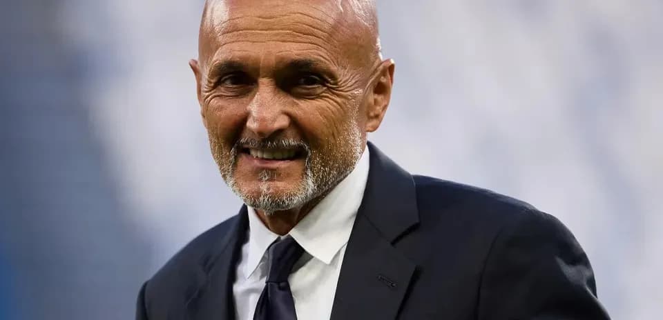 Man in suit smiling at stadium event