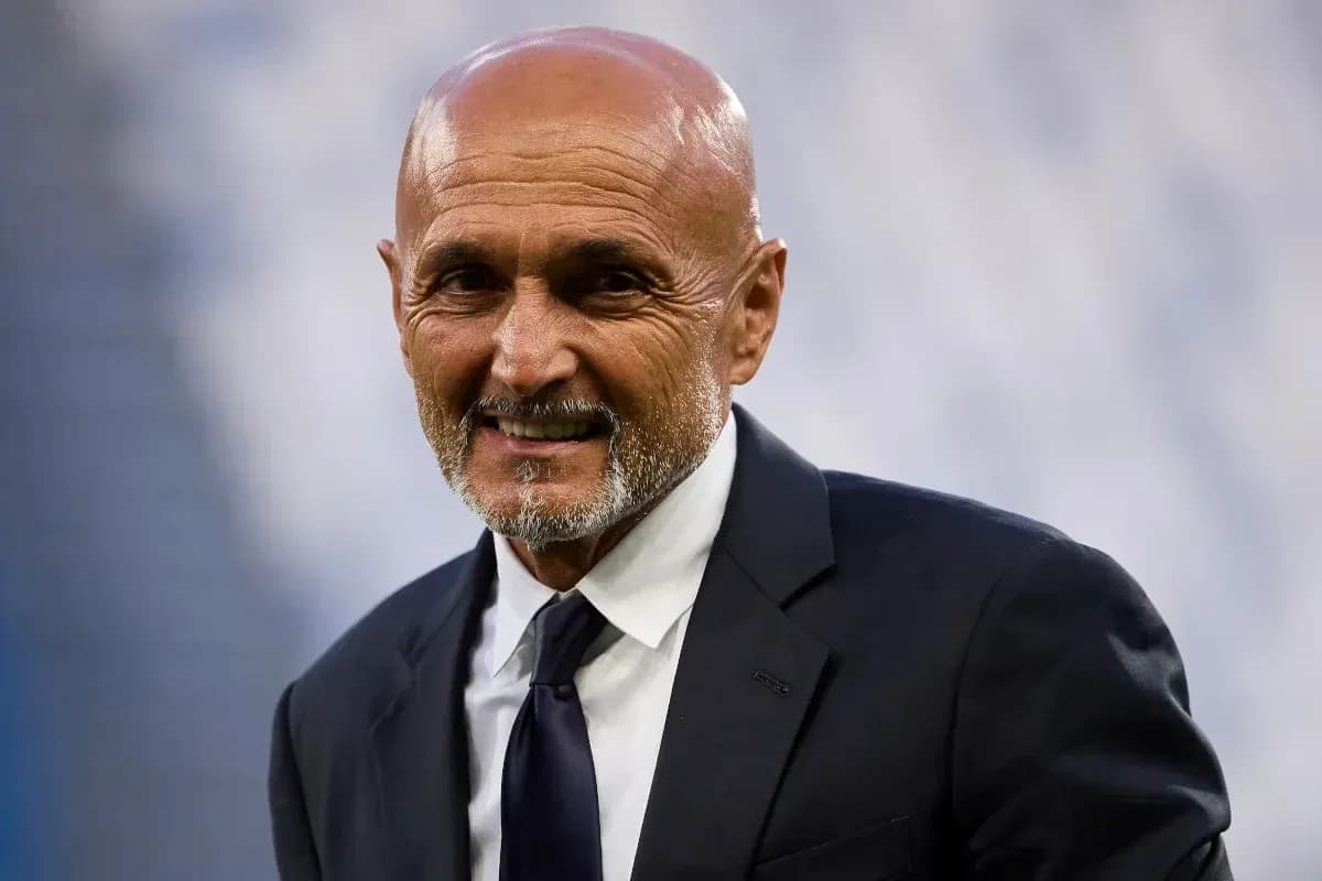 Man in suit smiling at stadium event
