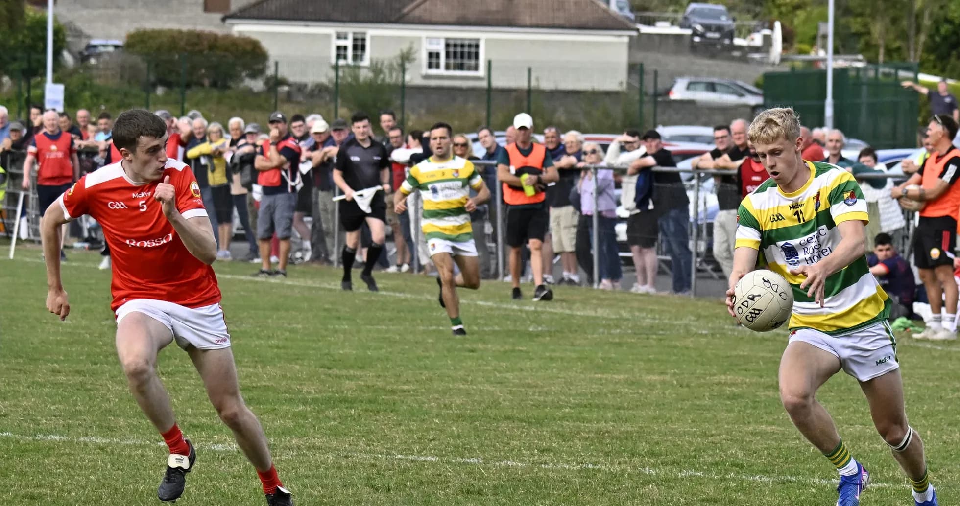 Player in green and yellow jersey receiving the ball