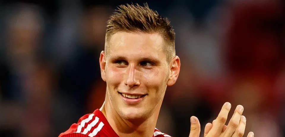 Player in red jersey smiling and applauding
